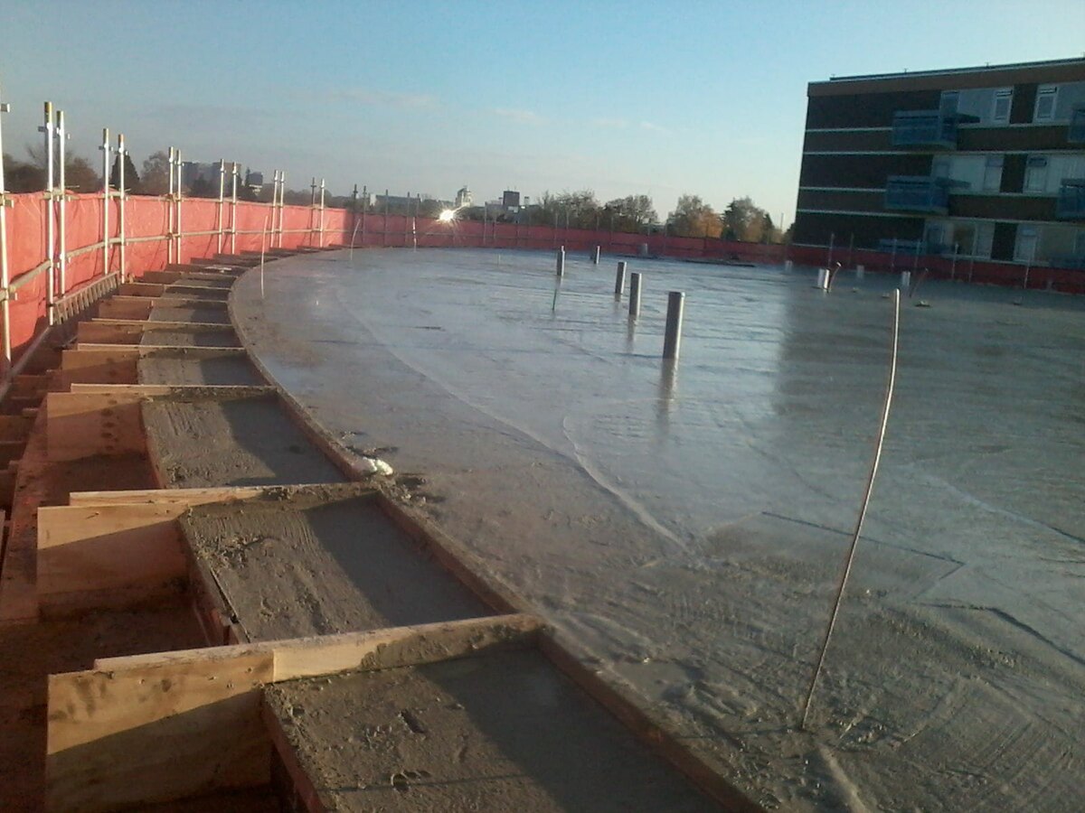 Gestorte betonvloer met houten bekisting op een civiel bouwproject